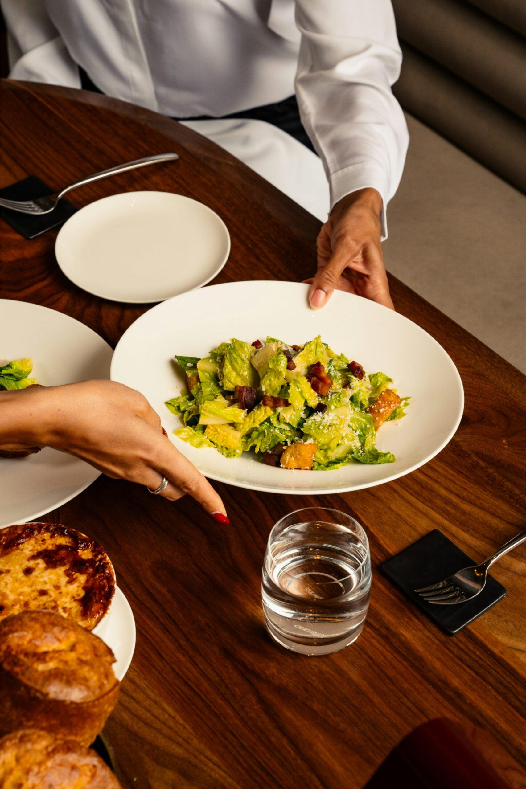 luxury fine dining table setting with caesar salad